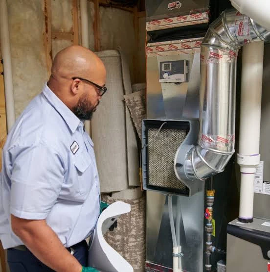 Technician inspecting an indoor furnace and its air filter