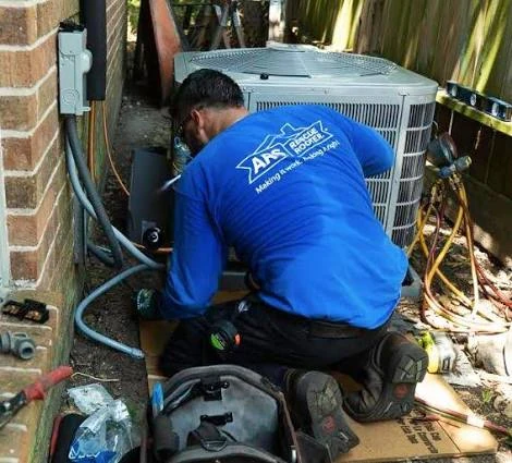 Technician in a blue work shirt repairing an outdoor air conditioner